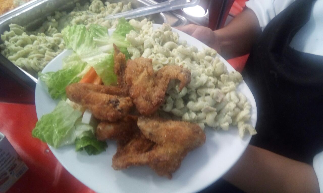 Ensalada con pollo, crutones y aderezo servida en comedor industrial